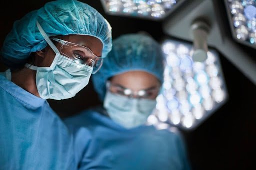 Ophtalmologue et infirmière dans un bloc opératoire au cours d'une chirurgie ophtalmologique