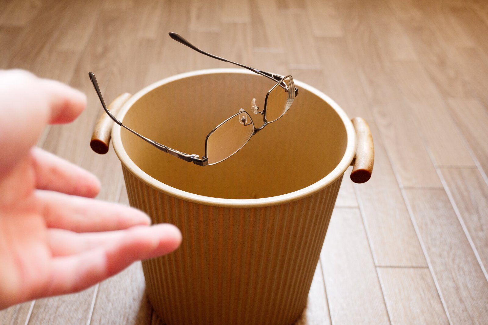 pole-ophtalmologie-colombes-la-defense photo d'une femme jetant ses lunettes à la poubelle après une chirurgie réfractive