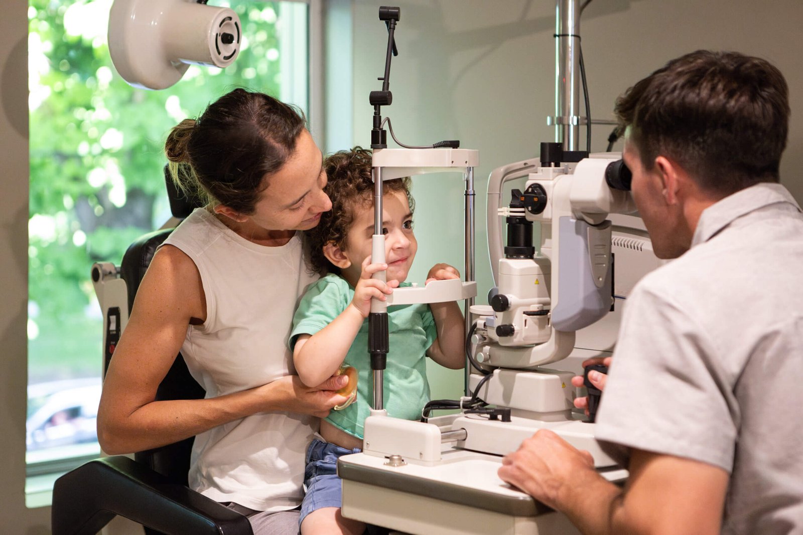 pole-ophtalmologie-colombes-la-defense enfant devant un appareil optique au cours d'une consultation d'ophtalmo-pédiatrie